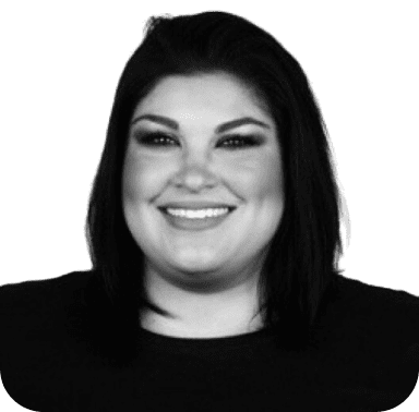 Black and white portrait of a smiling woman with shoulder-length hair against a green background.