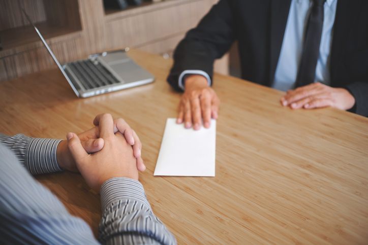 Businessman giving layoff letter to his employee.