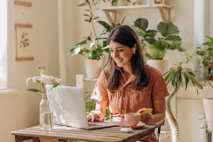 Woman sitting behind laptop smiling